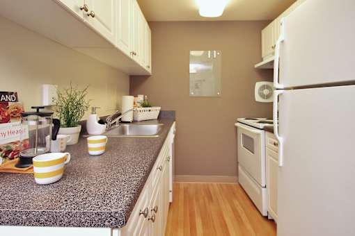 A kitchen with a granite countertop and white appliances.