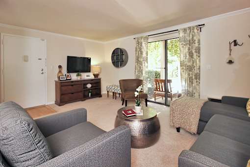 A living room with grey couches and a wooden coffee table.