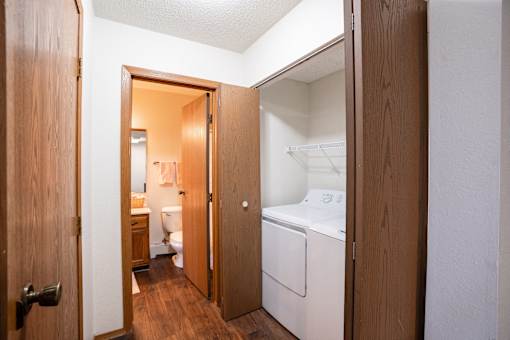 A small room with a washing machine in it. Fargo, ND Cedars 4 Apartments