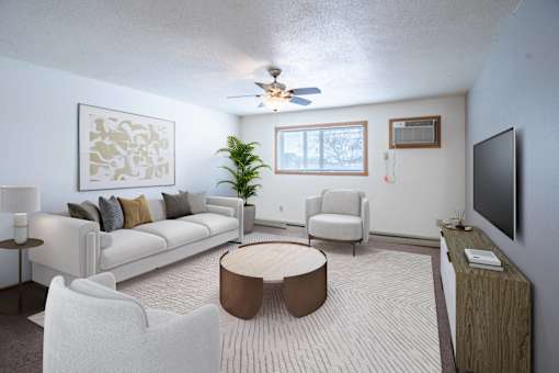 A living room with a white couch, a brown coffee table, and a flat screen TV. Fargo, ND Cedars 4 Apartments
