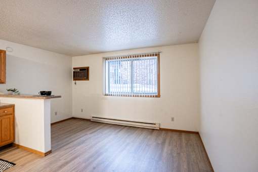 A room with a window and a wooden floor. Fargo, ND Candlelight Apartments