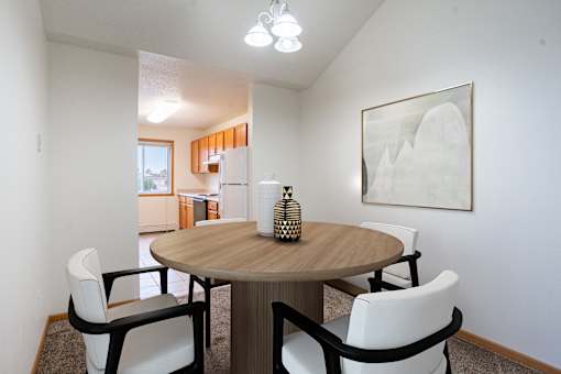 A dining room with a round table and chairs. Fargo, ND Summit Point Apartments