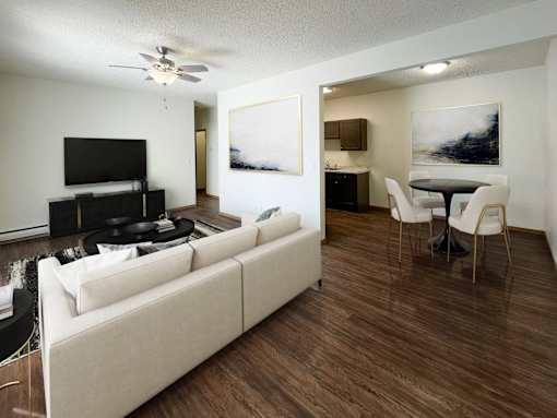 A living room with a white couch and a television. Bismarck, ND Belmont West Apartments