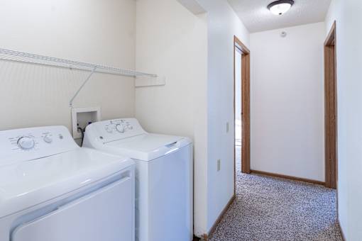 A small laundry room with a washer and dryer. Dilworth, MN Fieldstone Apartments