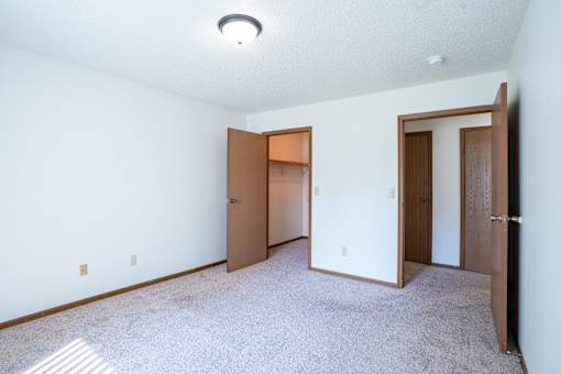 A room with two doors and a carpeted floor.