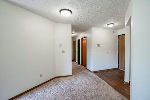 A long hallway with carpeted floors and white walls.