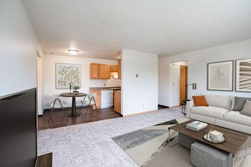 A living room with a couch, coffee table, and television. West Fargo, ND Saddlebrook Apartments