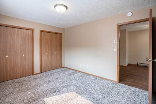 A room with two doors and a carpeted floor.