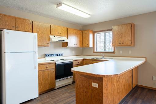 A kitchen with wooden cabinets and a white refrigerator.