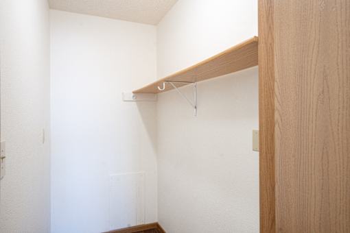 A white wall with a wooden shelf on it. Fargo, ND Fieldstone Apartments