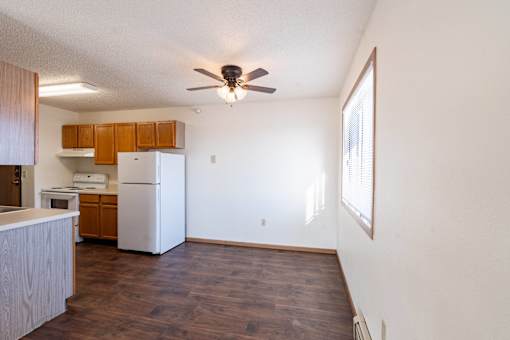 A kitchen with white appliances and wooden cabinets. Fargo, ND Fieldstone Apartments