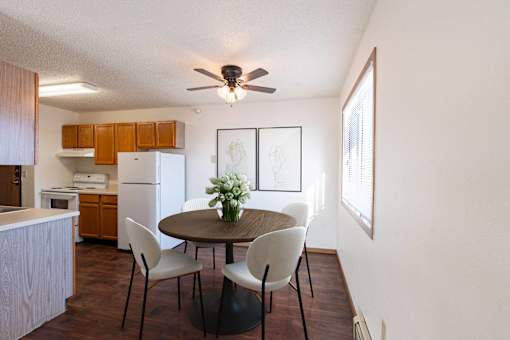 A dining room with a table and chairs. Fargo, ND Fieldstone Apartments