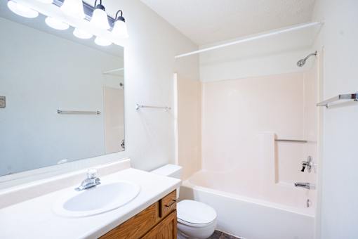 A white bathroom with a sink, toilet and bathtub. Fargo, ND Southgate Apartments