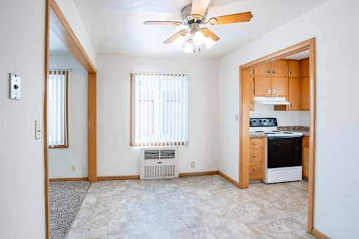 A room with a ceiling fan and a window with blinds. Fargo, ND L&R Apartments