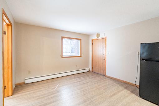 A room with a window and a door. Fargo, ND Birchwood Apartments
