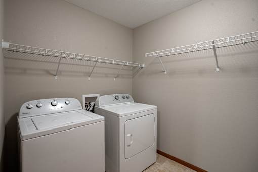 Two white front loading washing machines in a laundry room. Fargo, ND Urban Plains Apartments