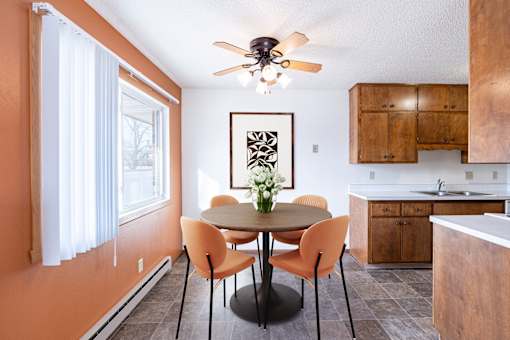 A dining room with a table and chairs. Fargo, ND Carr Apartments