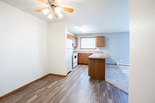 A room with a ceiling fan and wooden flooring. Fargo, ND Westwood Estates