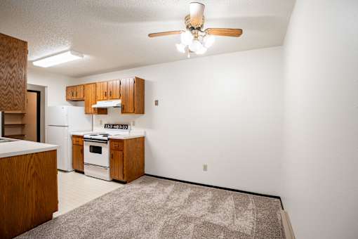 A kitchen with wooden cabinets and a white oven.