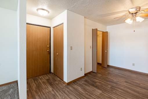 A room with wooden floors and three doors. Fargo, ND Kennedy Apartments