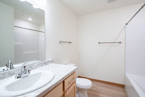 A white sink with a silver faucet is on a marble countertop. Cherry Creek Apartments