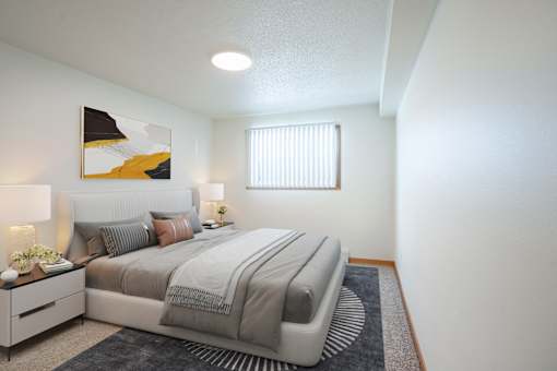 A bedroom with a large bed and a painting on the wall. Grand Forks, ND Cherry Creek Apartments
