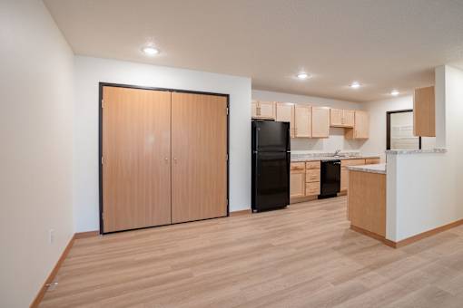 A kitchen with wooden floors and cabinets. Cherry Creek Apartments