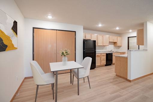 A modern kitchen with a dining table and chairs. Grand Forks, ND Cherry Creek Apartments