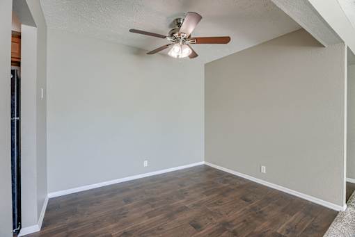 A room with a ceiling fan and wooden flooring. Omaha, NE Evergreen Terrace Apartments