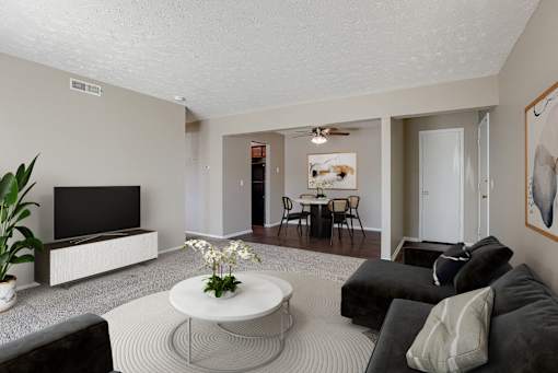 A living room with a television, couches, and a coffee table. Omaha, NE Evergreen Terrace Apartments