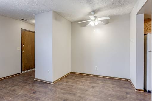 A room with a ceiling fan and a door. Omaha, NE Stony Brook Apartments