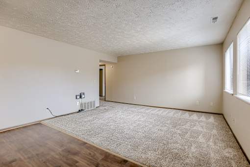 A room with a carpet, wooden floor and a window. Omaha, NE Stony Brook Apartments