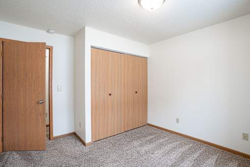A room with two doors and a carpeted floor. Fargo, ND Long Island Apartments