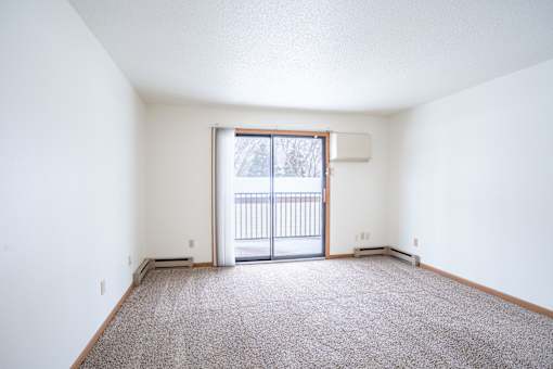 A room with a carpeted floor and a sliding glass door. Fargo, ND Long Island Apartments