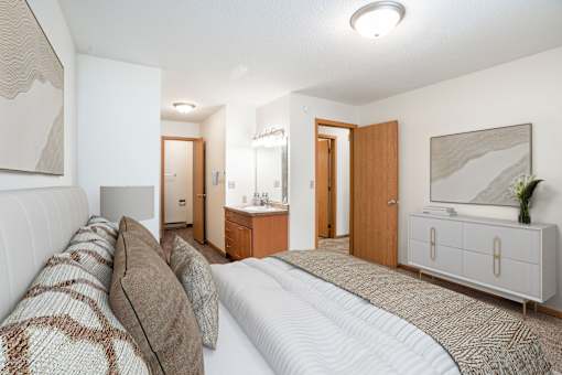 A bedroom with a large bed and a television. Fargo, ND Long Island Apartments