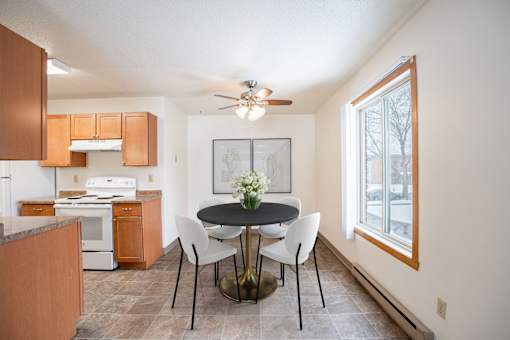 A kitchen with a table and chairs in the middle of the room. Fargo, ND Long Island Apartments