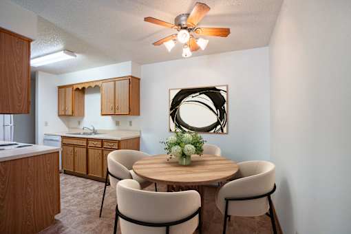 A dining room with a round table and chairs.