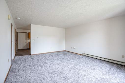 A large empty room with a carpeted floor and white walls. Fargo, ND Hazelwood Townhomes