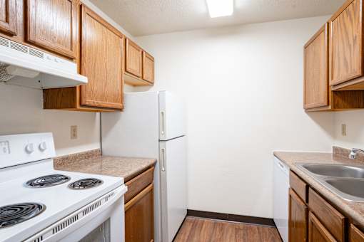 A kitchen with a white stove and a white refrigerator. Fargo, ND Summerfield Apartments