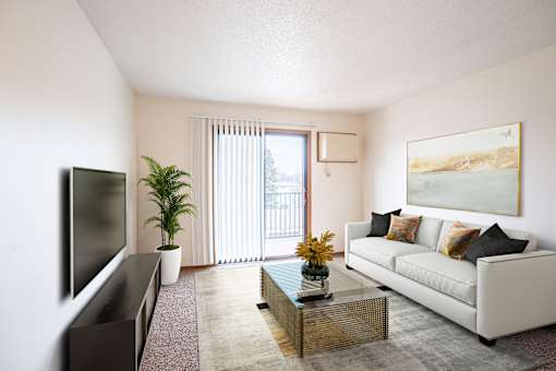 A living room with a white couch, a flat screen TV, a coffee table, and a painting on the wall. Fargo, ND Hawthorn Apartments
