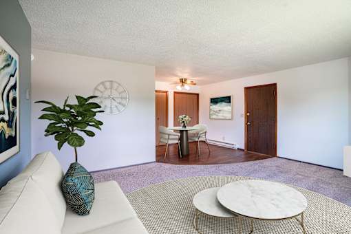 A living room with a white couch and a round coffee table. Fargo, ND Summerfield Apartments