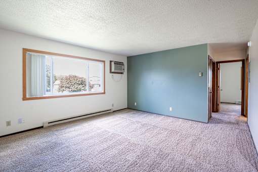 A room with a window and a door. Fargo, ND Summerfield Apartments