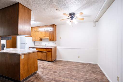 A kitchen with wooden cabinets and a ceiling fan. Fargo, ND Park Terrace Apartments