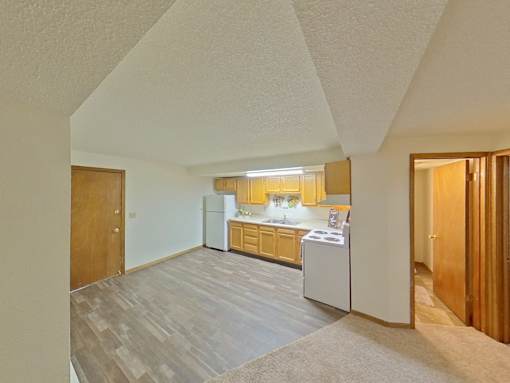 A kitchen with a white fridge and a white washing machine.
