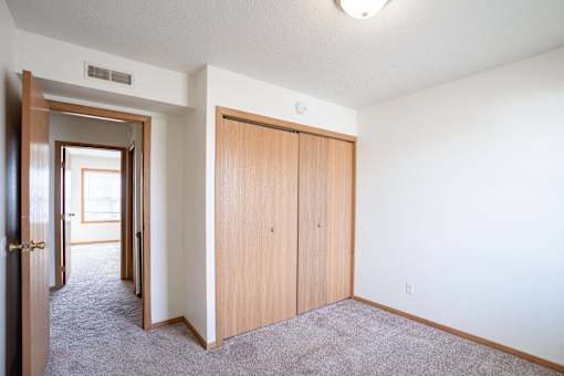 A room with a carpeted floor and a white ceiling with a light fixture. West Fargo, ND Sheyenne Terrace Townhomes