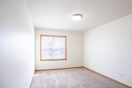 A room with a window and carpet on the floor. West Fargo, ND Sheyenne Terrace Townhomes