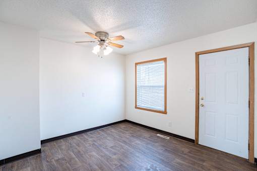 A room with a ceiling fan and a door. West Fargo, ND Sheyenne Terrace Townhomes
