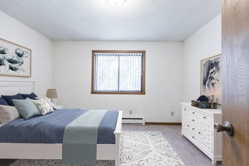 Bismarck, ND Arbor apartments. a bedroom with a bed and a dresser