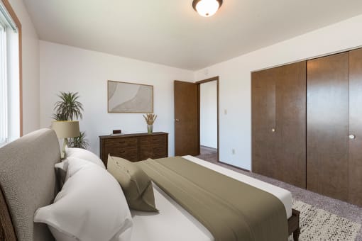 Bismarck, ND Brentwood II Apartments. A bedroom with a bed and dresser Brentwood II| Bismarck, ND
