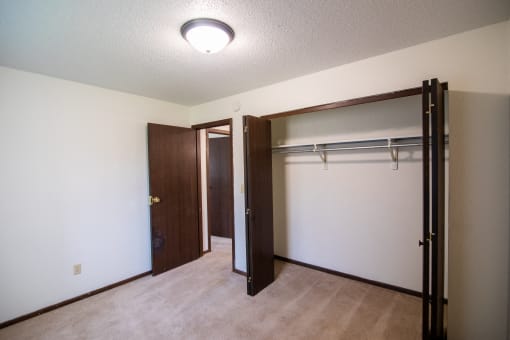 A bedroom with a closet. Bismarck, ND Eastbrook Apartments.